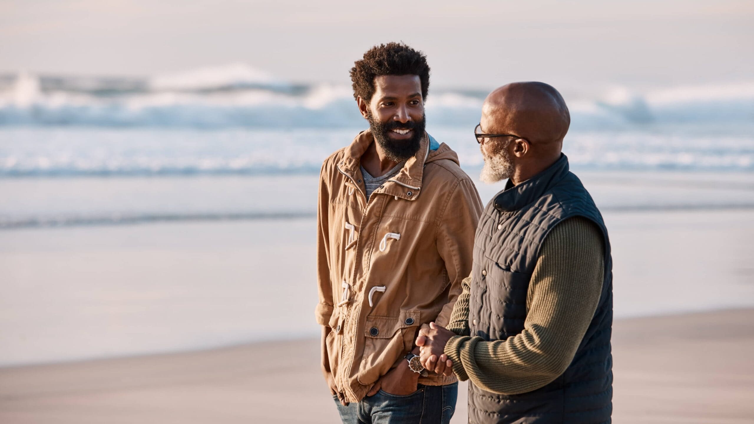 August 7th blog older African-American man walking on beach having a talk with his adult son