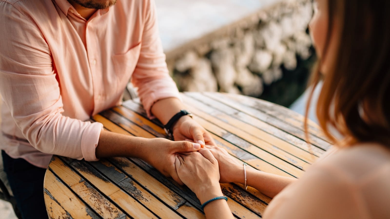 low-income man and woman sitting at table holding hands