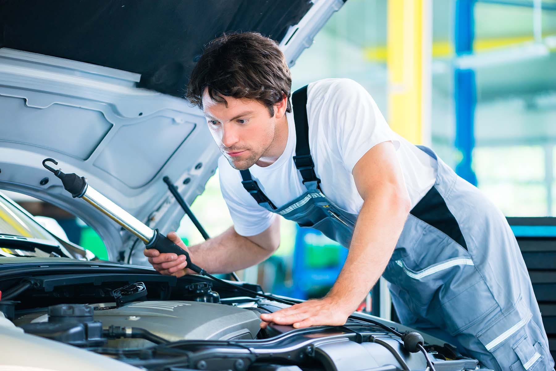 Auto mechanic working in car service workshop