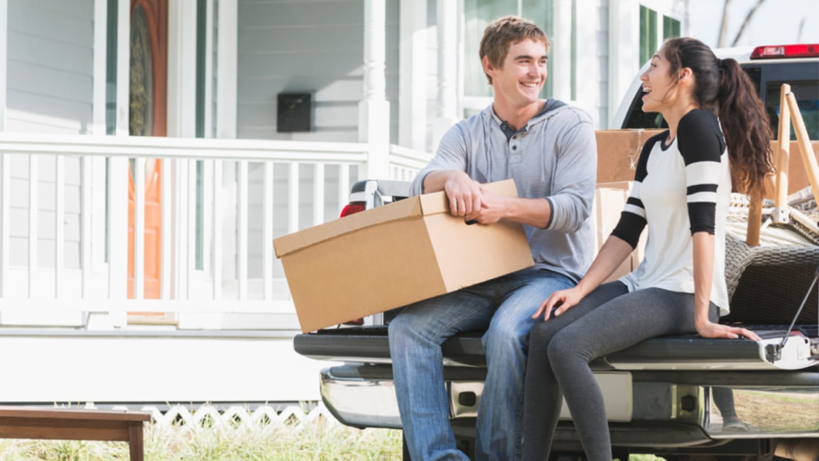 Young couple sitting on a pickup truck tailgate