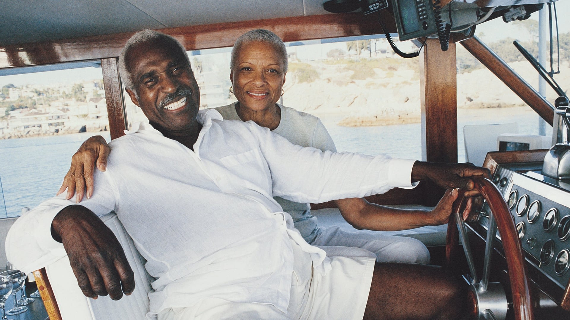 High-net-worth couple sitting on their boat and smiling at the camera