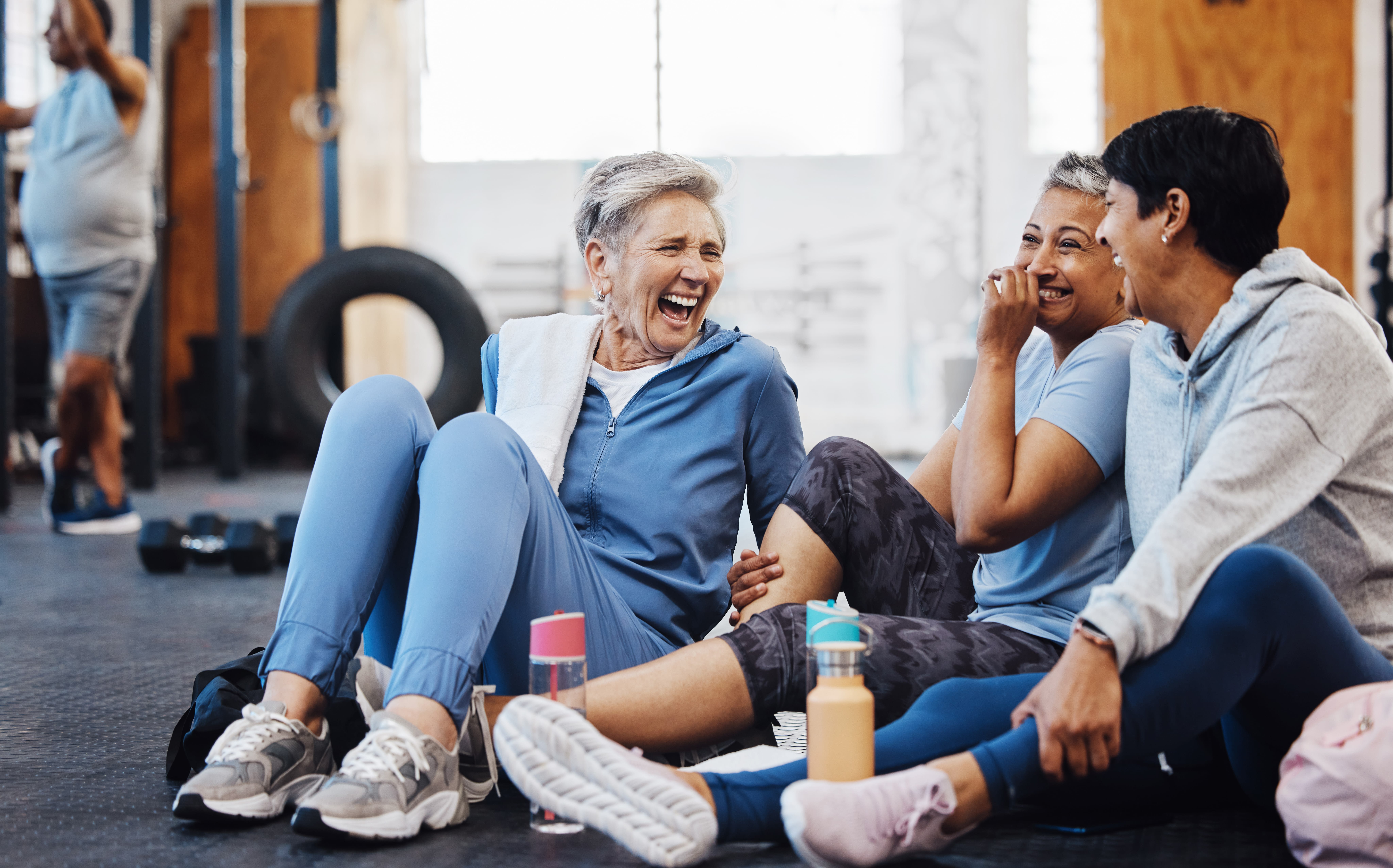 Gym, laughing and group of mature women telling joke after fitness class