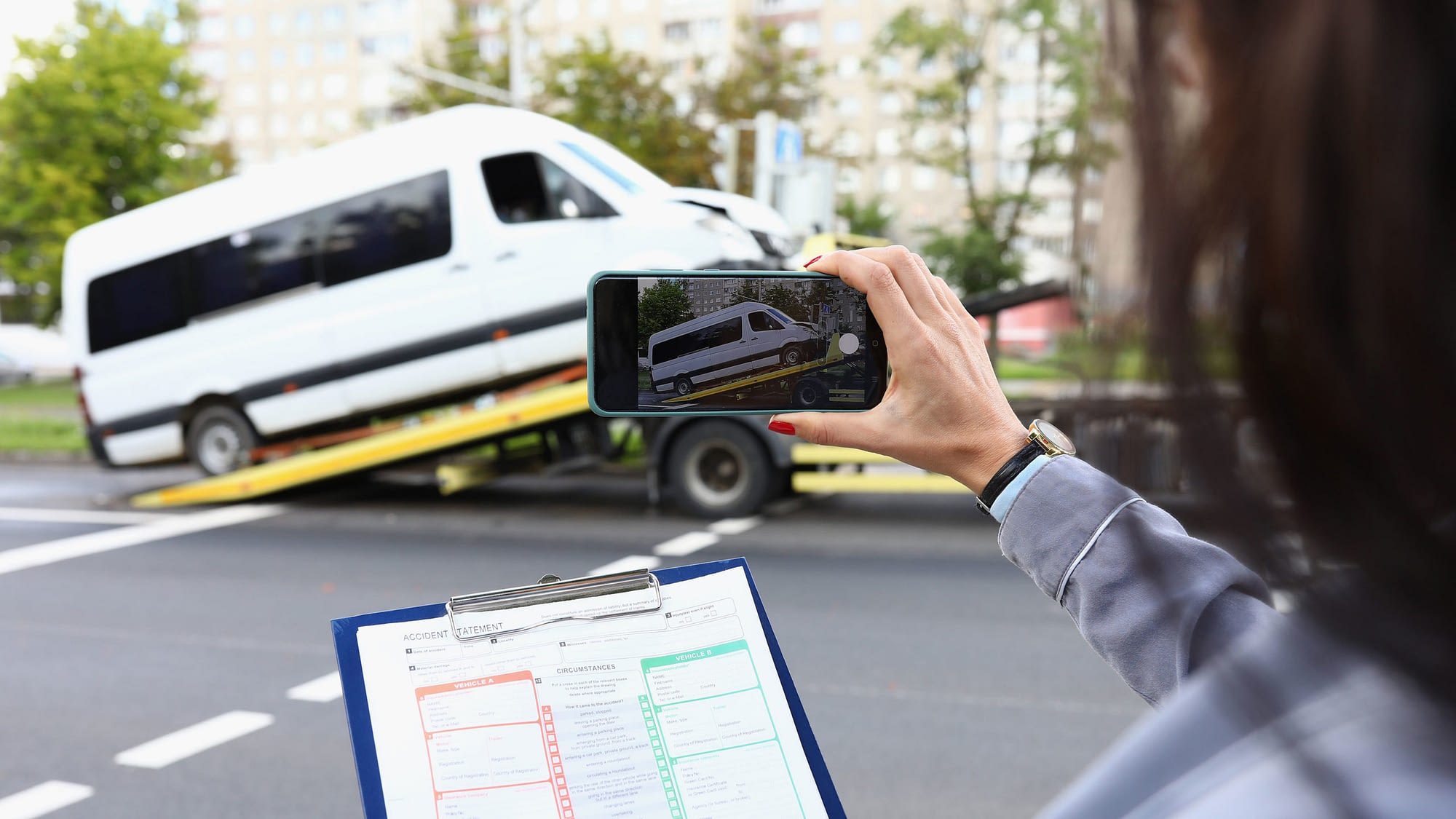 Individual taking photo of their commercial shuttle bus being towed away.