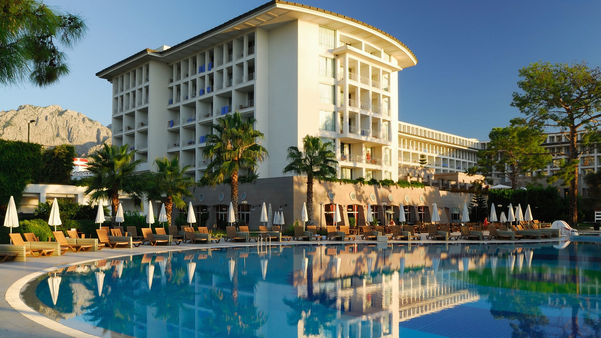 Exterior view of nice hotel with pool in the foreground.