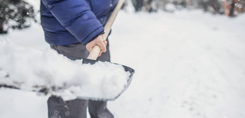 Person Holding a Shovel Full of Snow