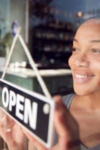 Business owner displaying an OPEN sign on the door.
