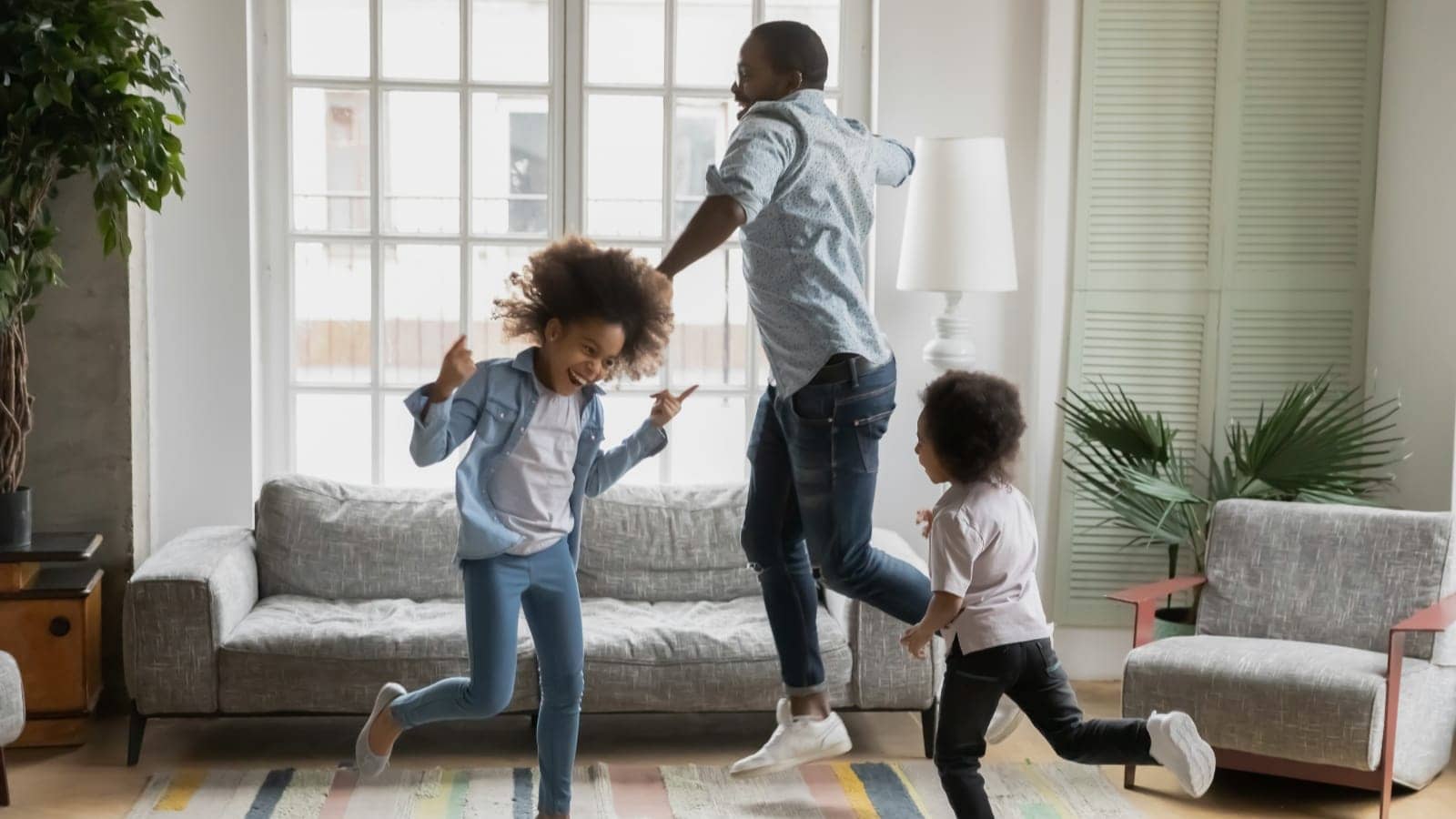 father and kids dancing in the living room