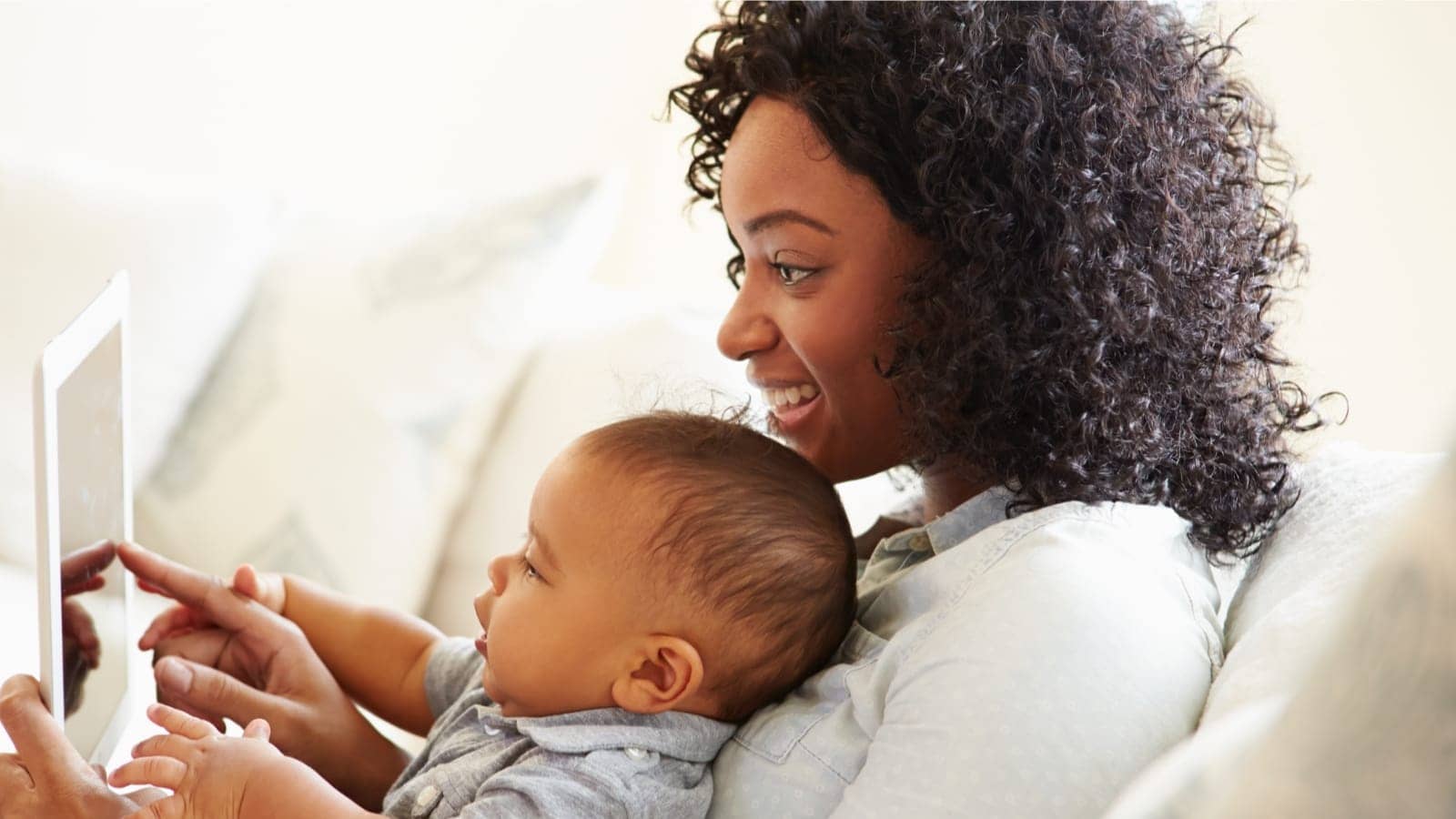 african american mother showing her infant child a tablet