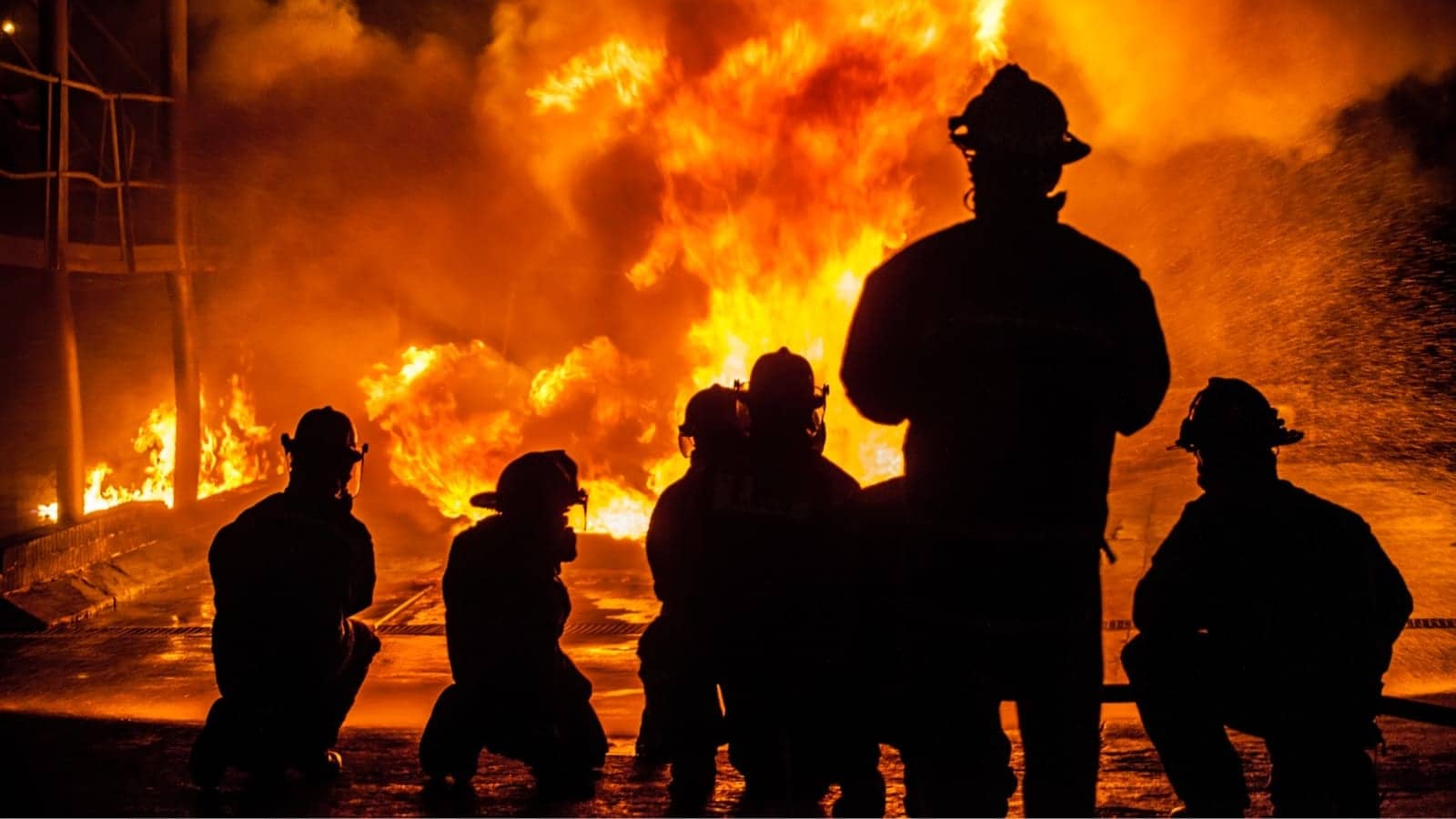 firefighter's silhouettes watching a fire burn
