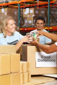 Volunteers accepting donations from a woman.