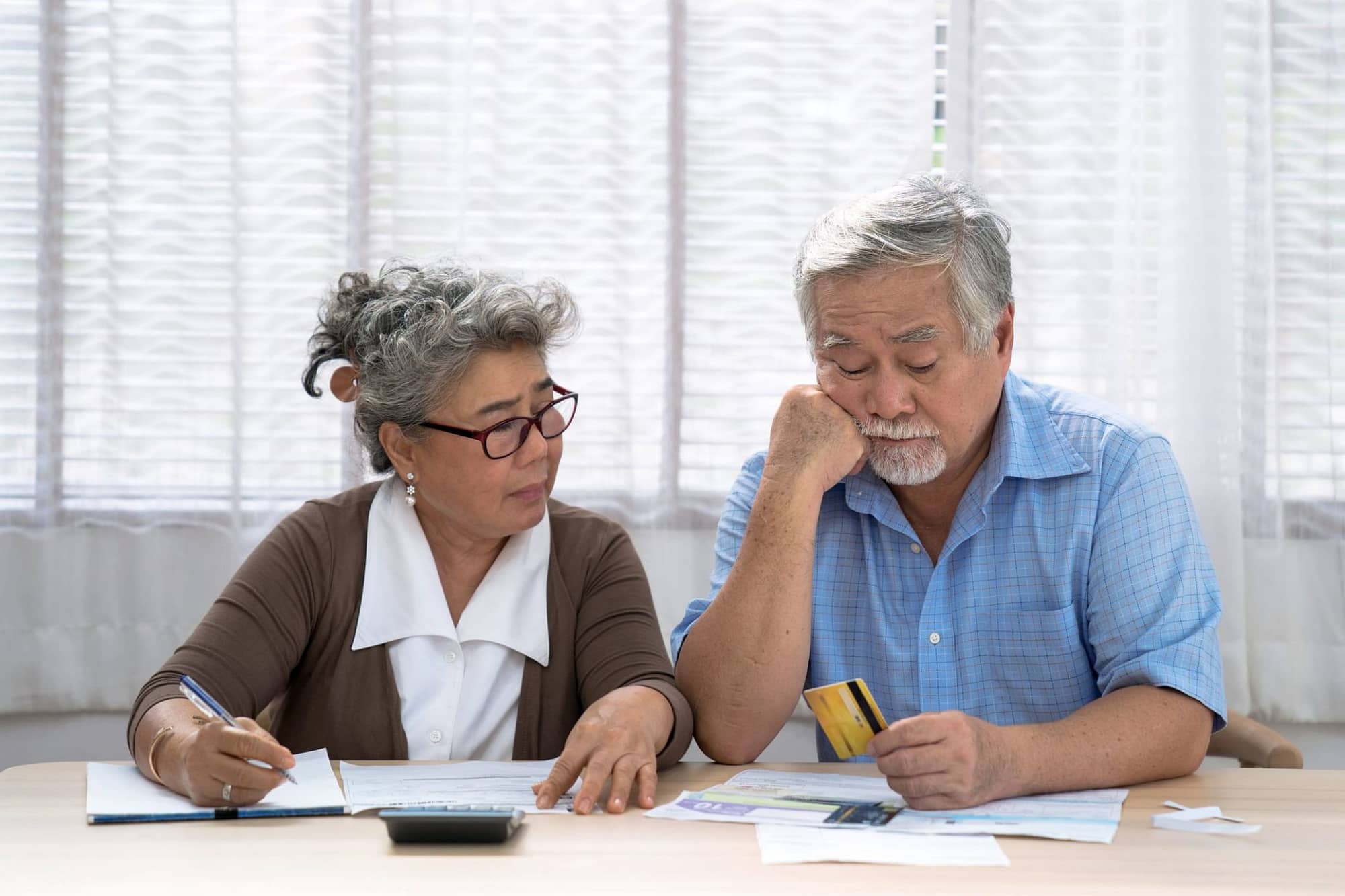 Stressed Asian Couple Looking at Paperwork