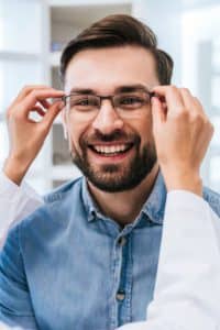Man getting fitted with new glasses by an optometrist.
