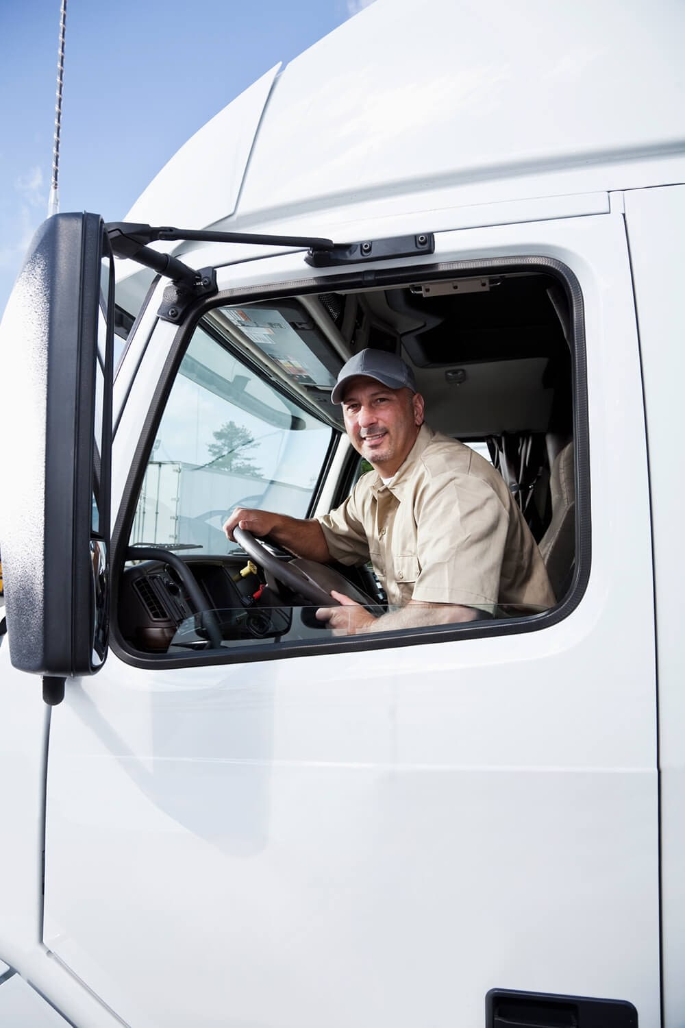 truck-driver-sitting-in-cab-of-semitruck truck driver sitting in a cab of semi truck