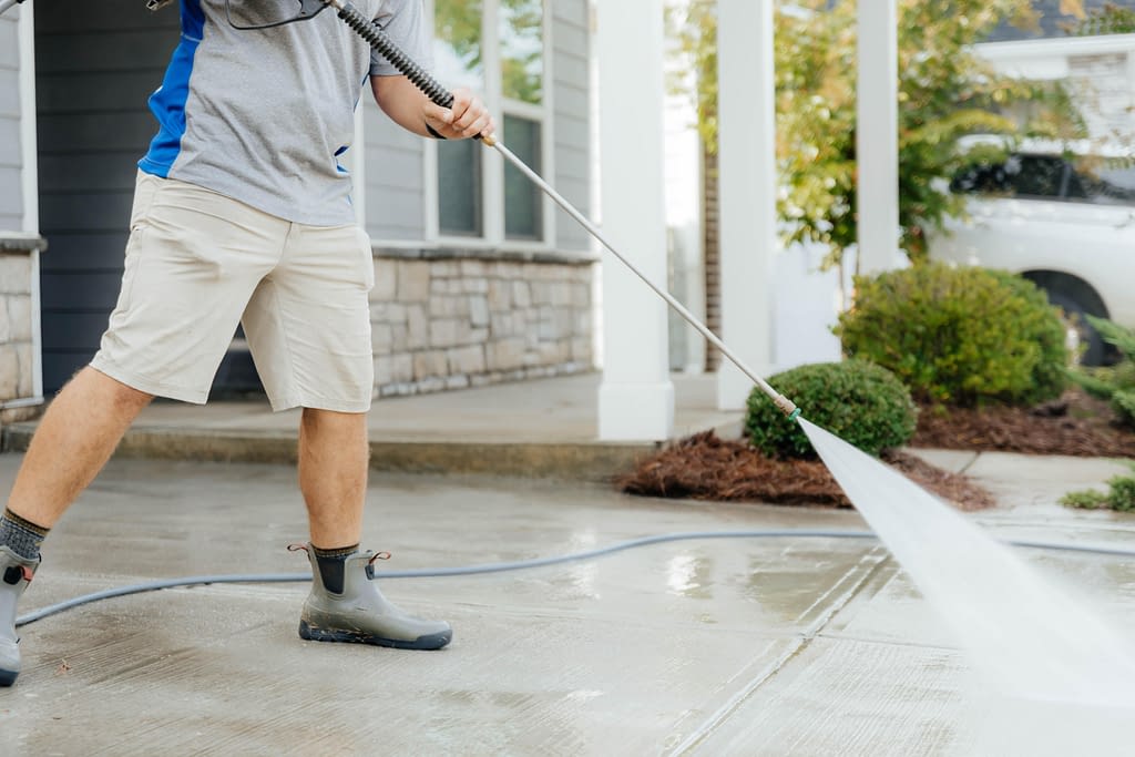 Man power-washing driveway