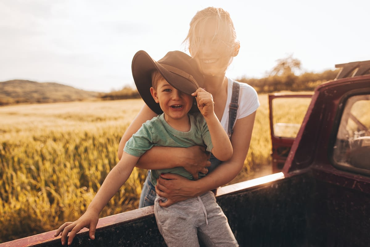 young mom and son in the back tailgate on a field