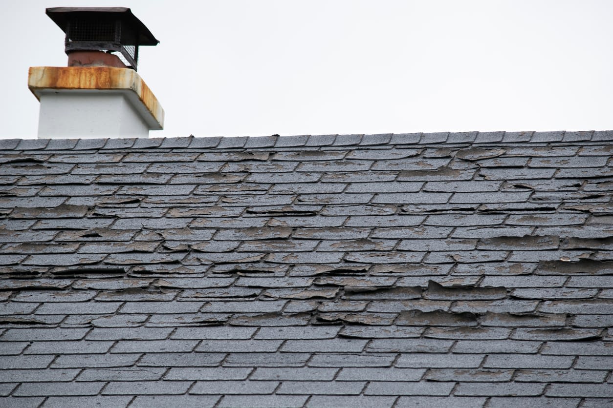 Damaged and old roofing shingles and gutter system on a house Damaged and old roofing shingles and gutter system on a house
