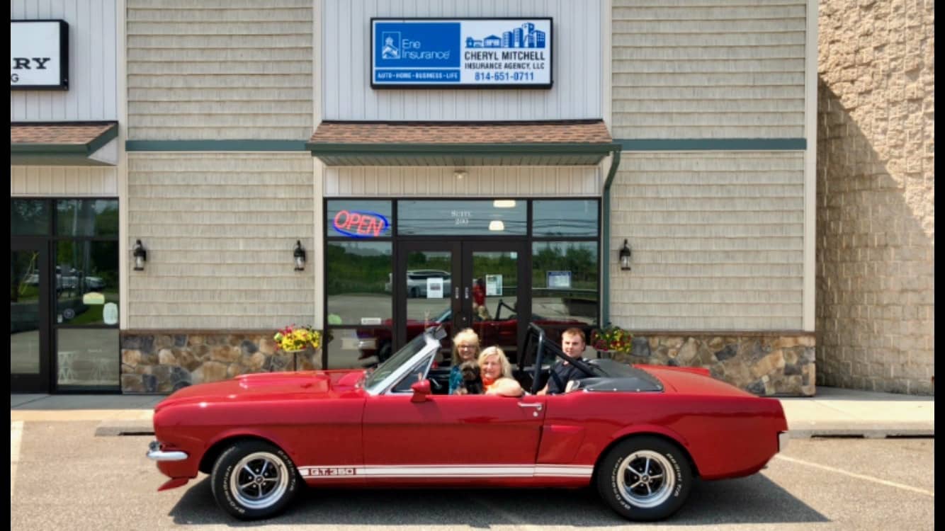 Cheryl Mitchell and her team in a classic car