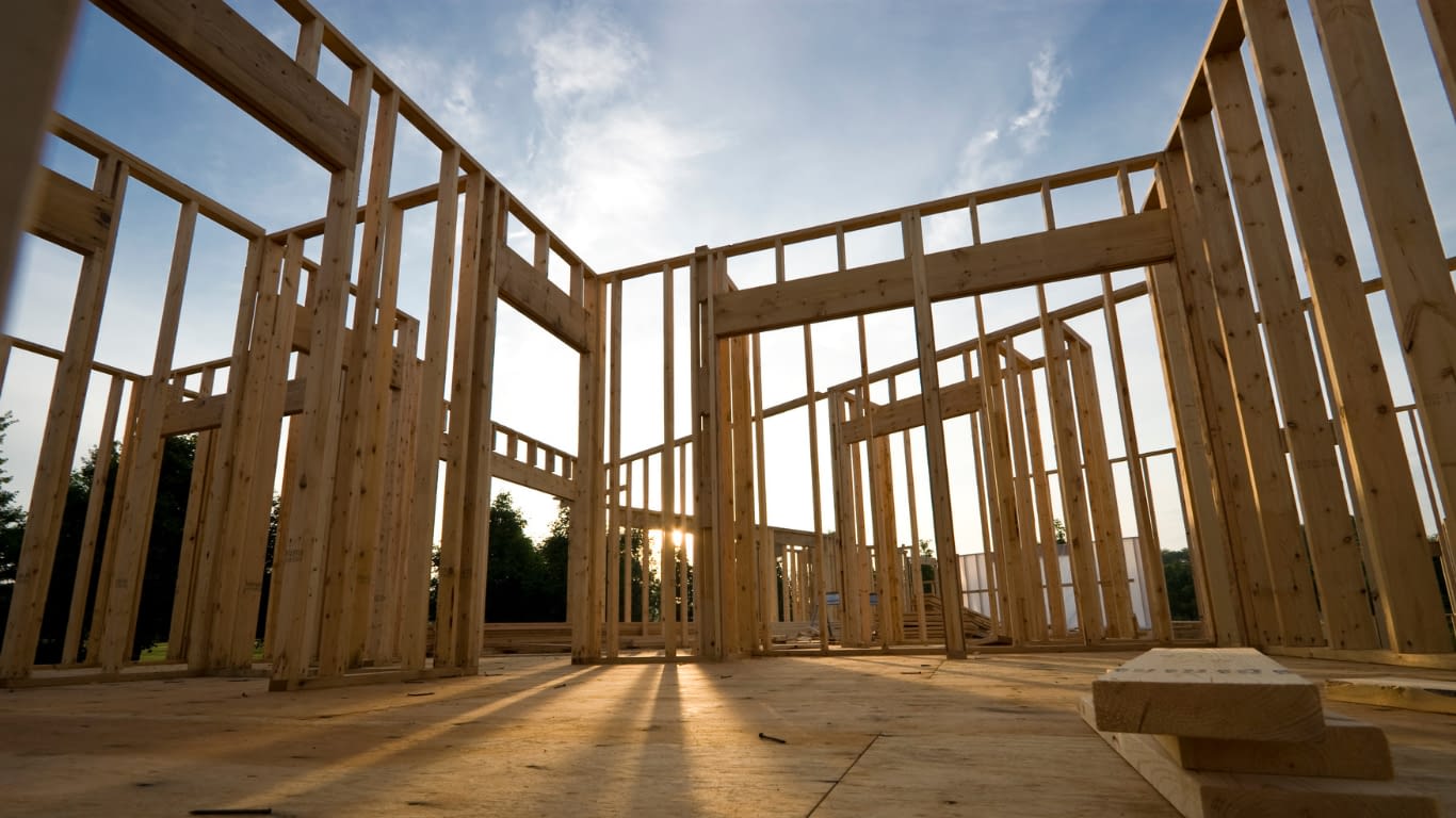 Home Construction Home frame under constructing with setting sun in the background