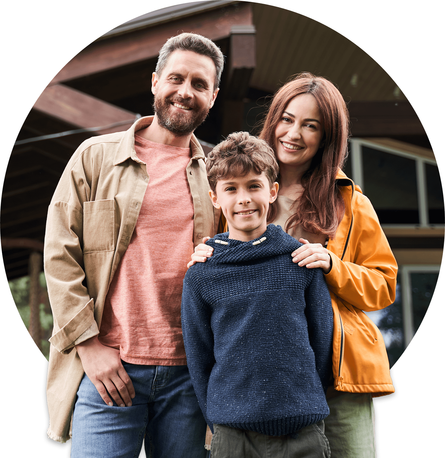 family of three in front of a house smiling