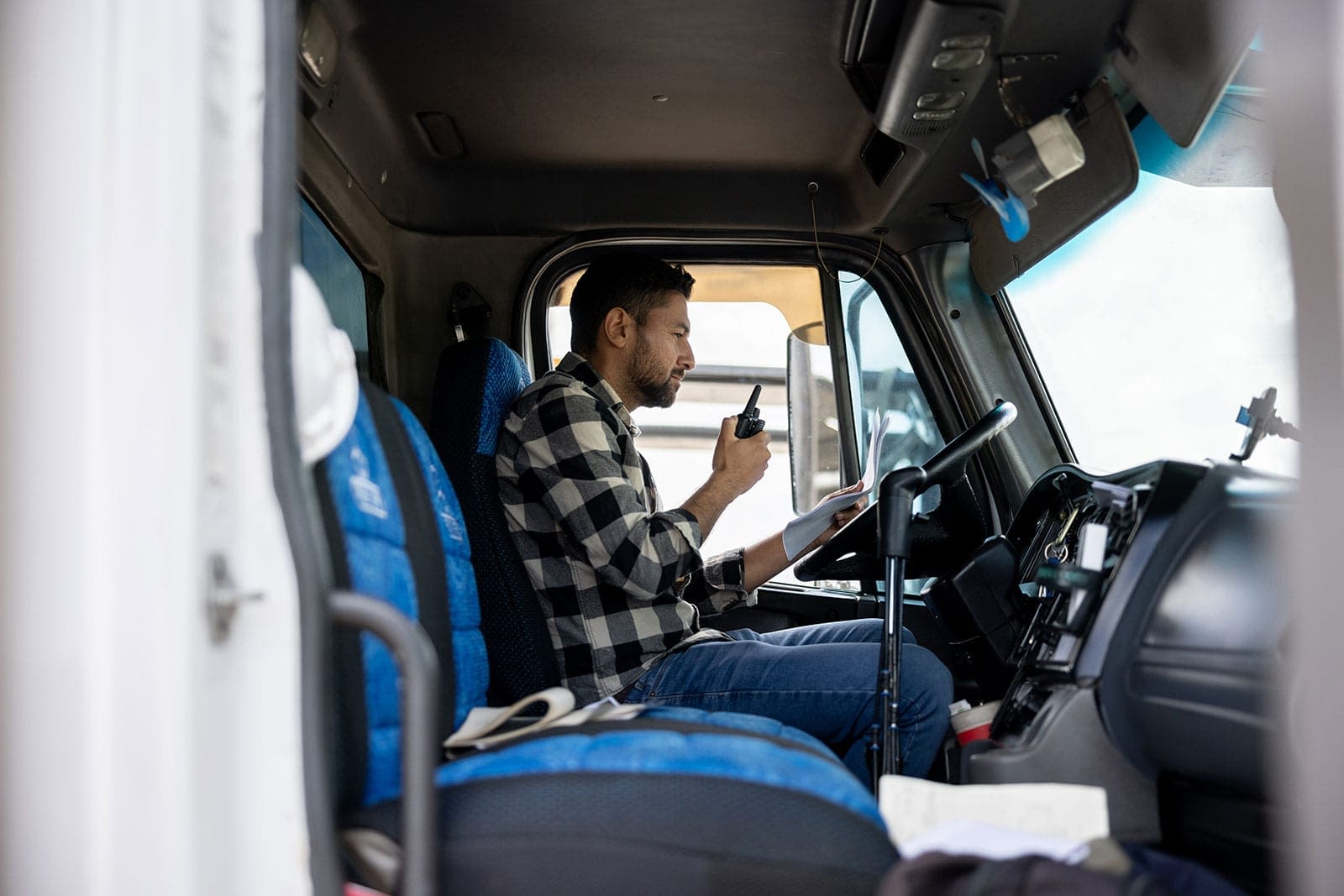 truck-driver-with-paperwork-taking-on-radio