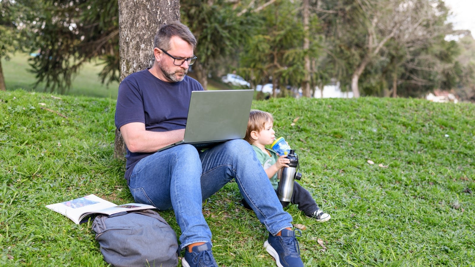 grad student working with toddler beside him