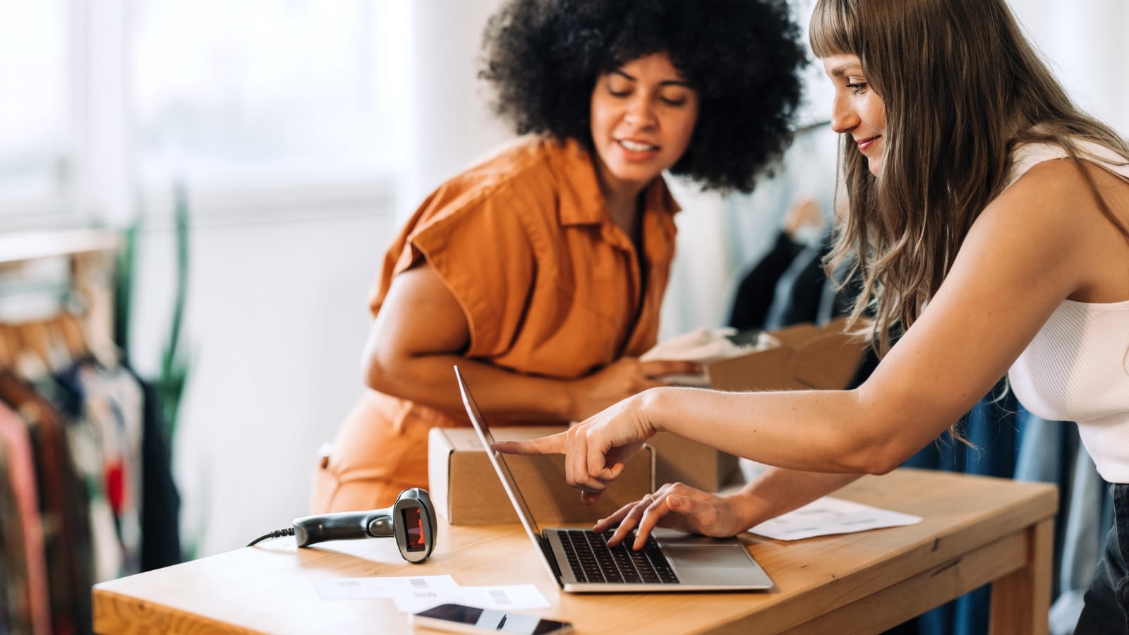 two female small business owners looking at something on their laptop