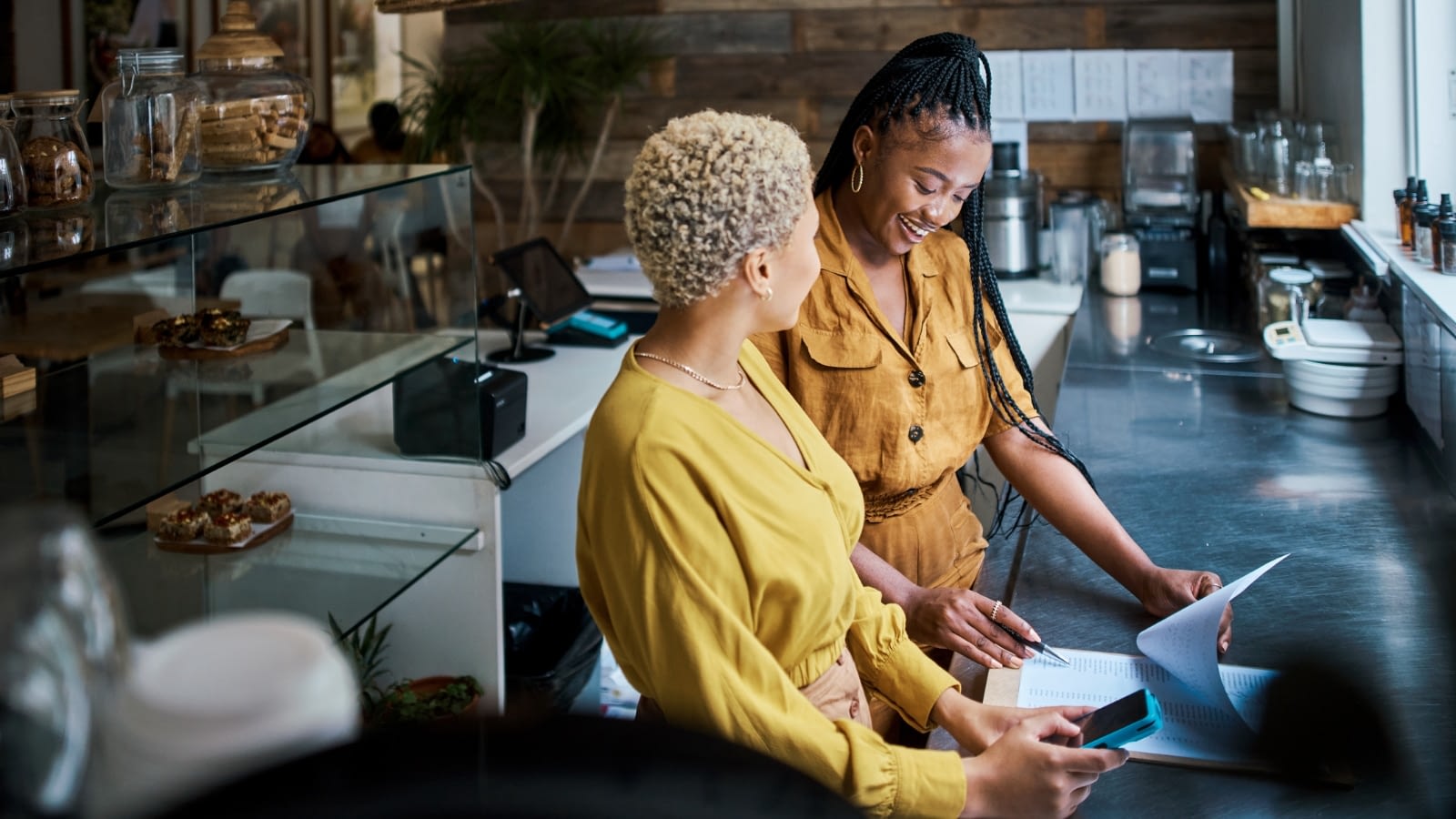 Two African-American female restaurant owners discussing business.