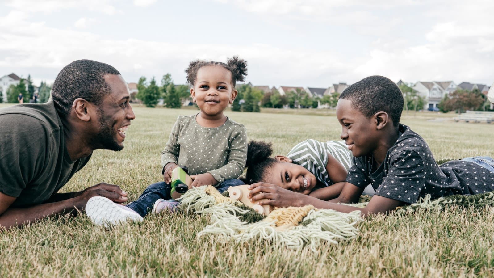 April 7 blog African-American father playing in field with his two young children.