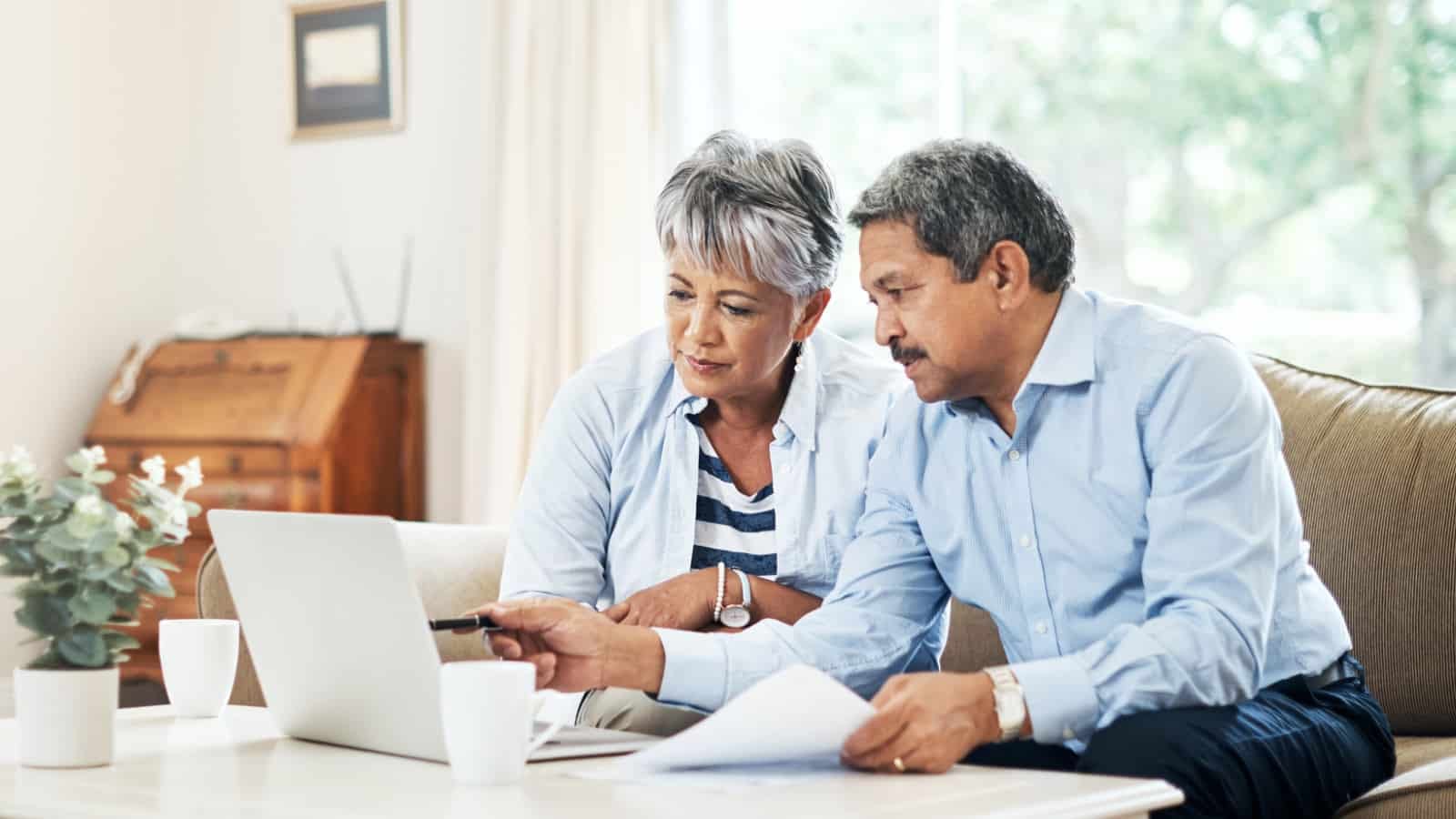 Older hispanic couple reading something together on laptop