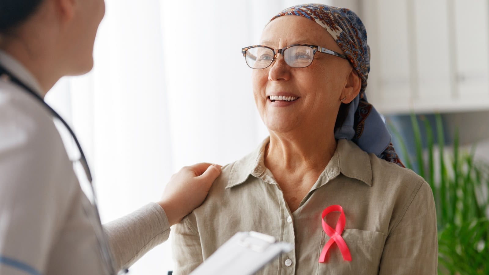 Happy breast cancer patient speaking with her doctor