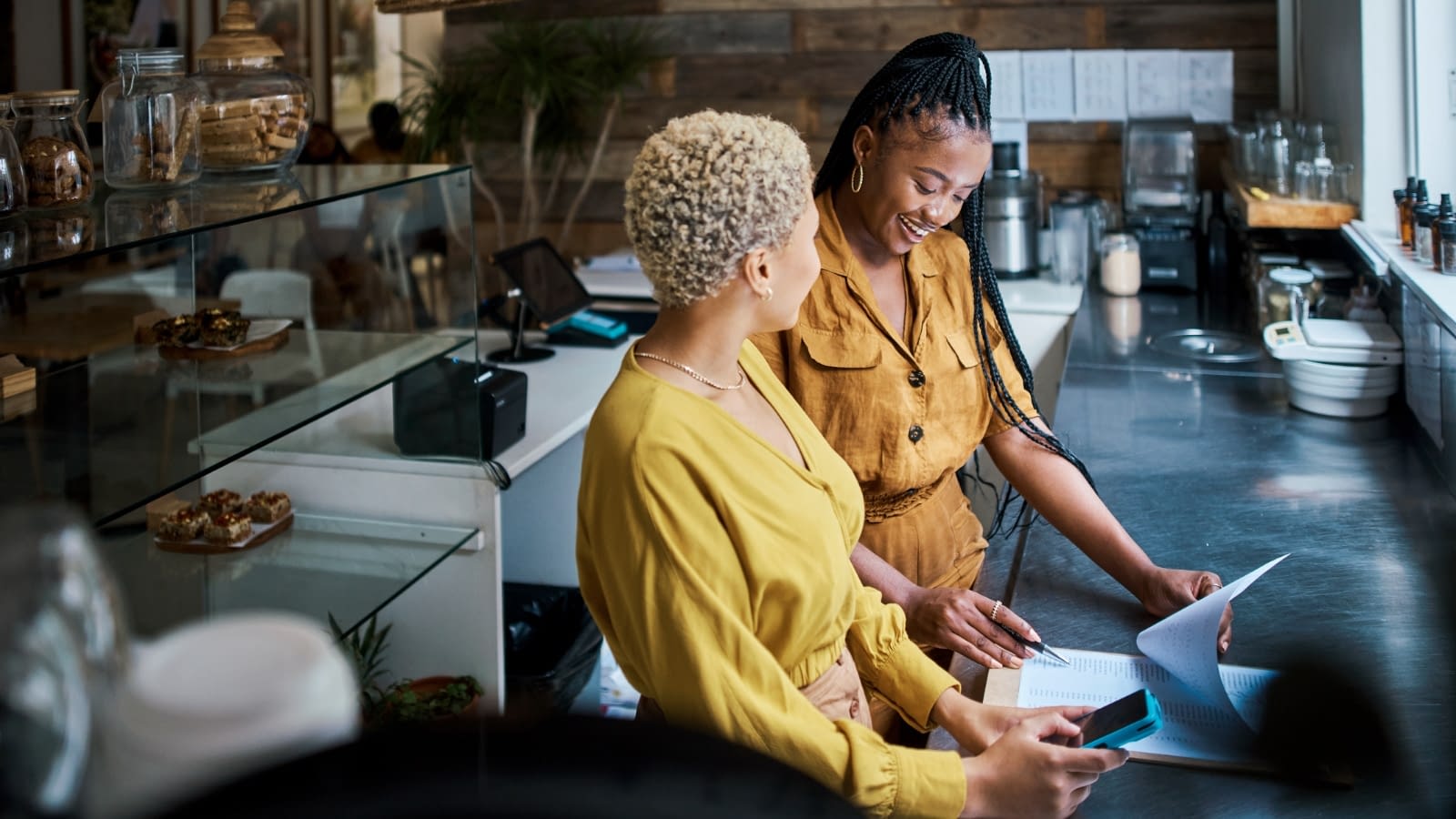 Mar 4 blog Two African-American female restaurant owners discussing business.