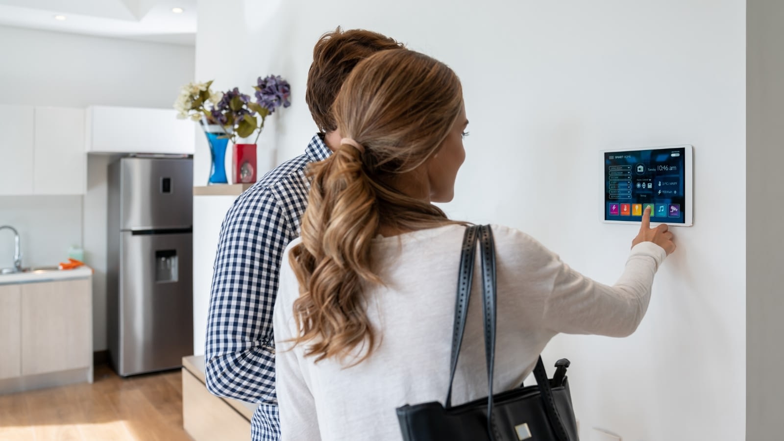 Young couple setting home security system before leaving house