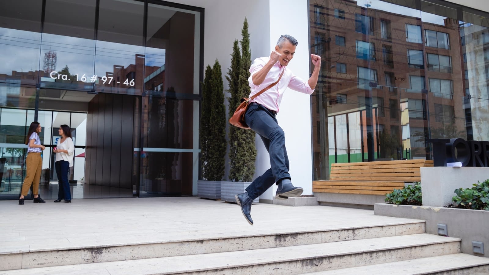 group benefits leap businessman excitedly jumping down stairs outside