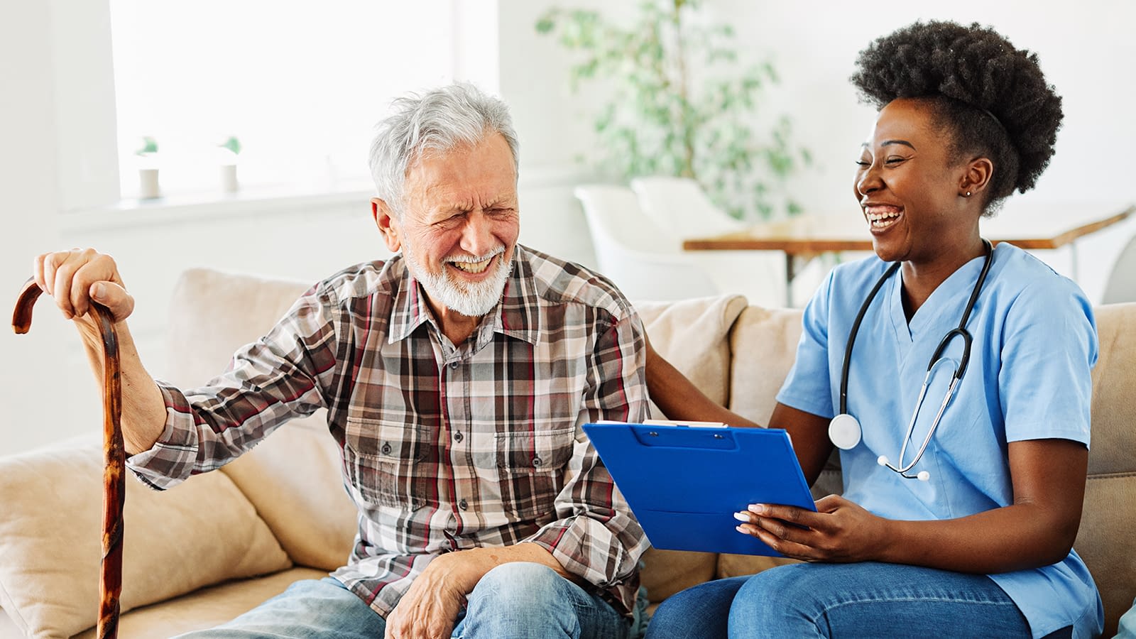 Older Man Laughing with Health Aid Older Man Laughing with Home Nurse Aid