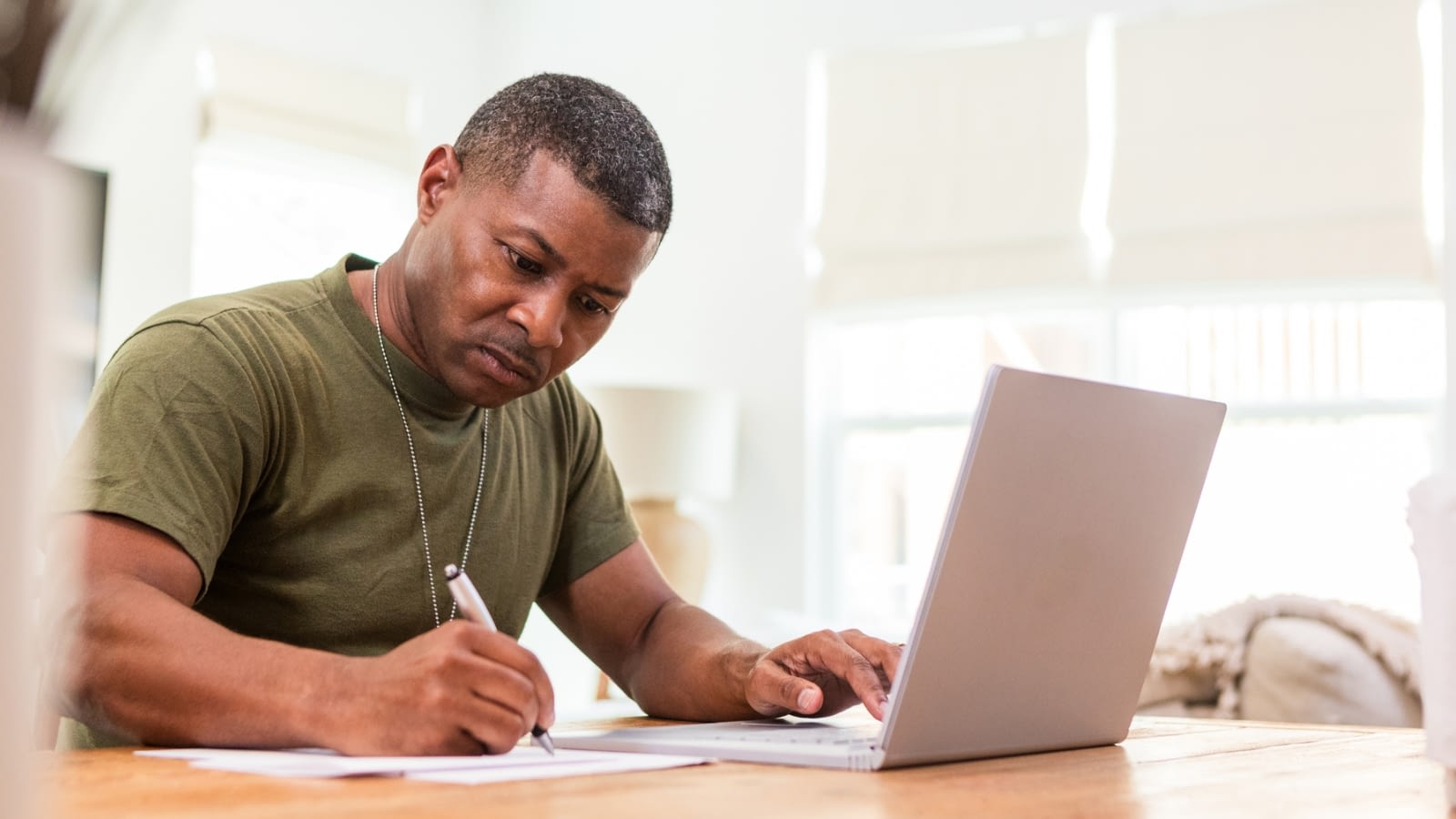 veteran businessman writing and working on laptop