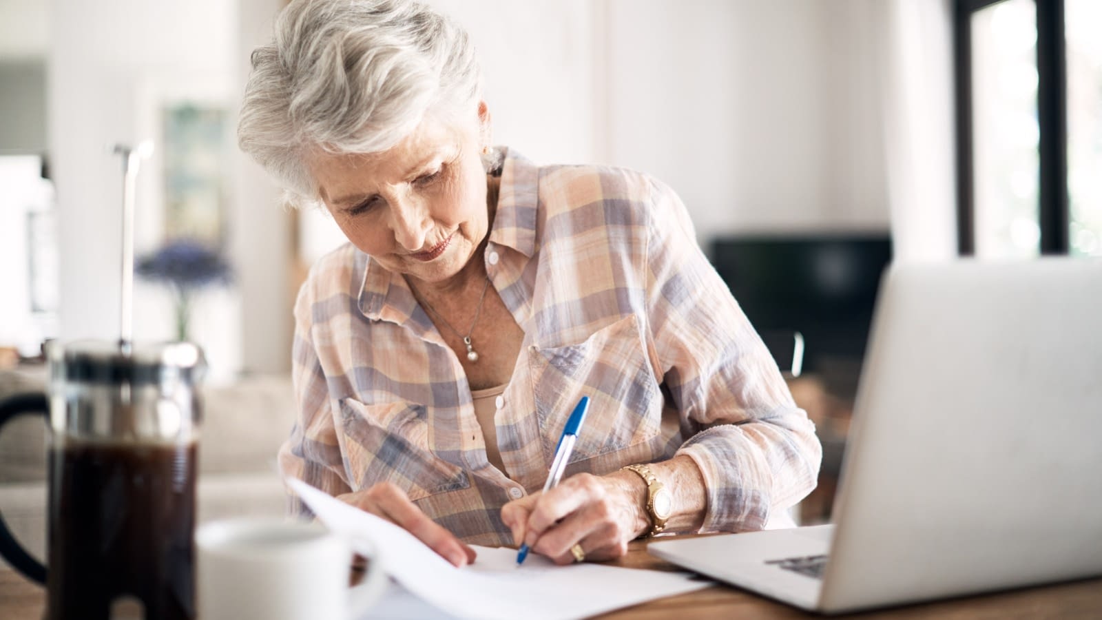 Mature person writing something Senior woman doing paperwork