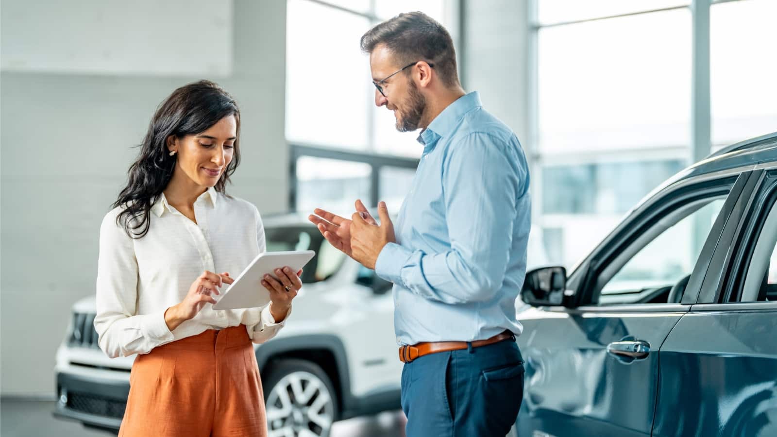 Woman signing paperwork at car dealership