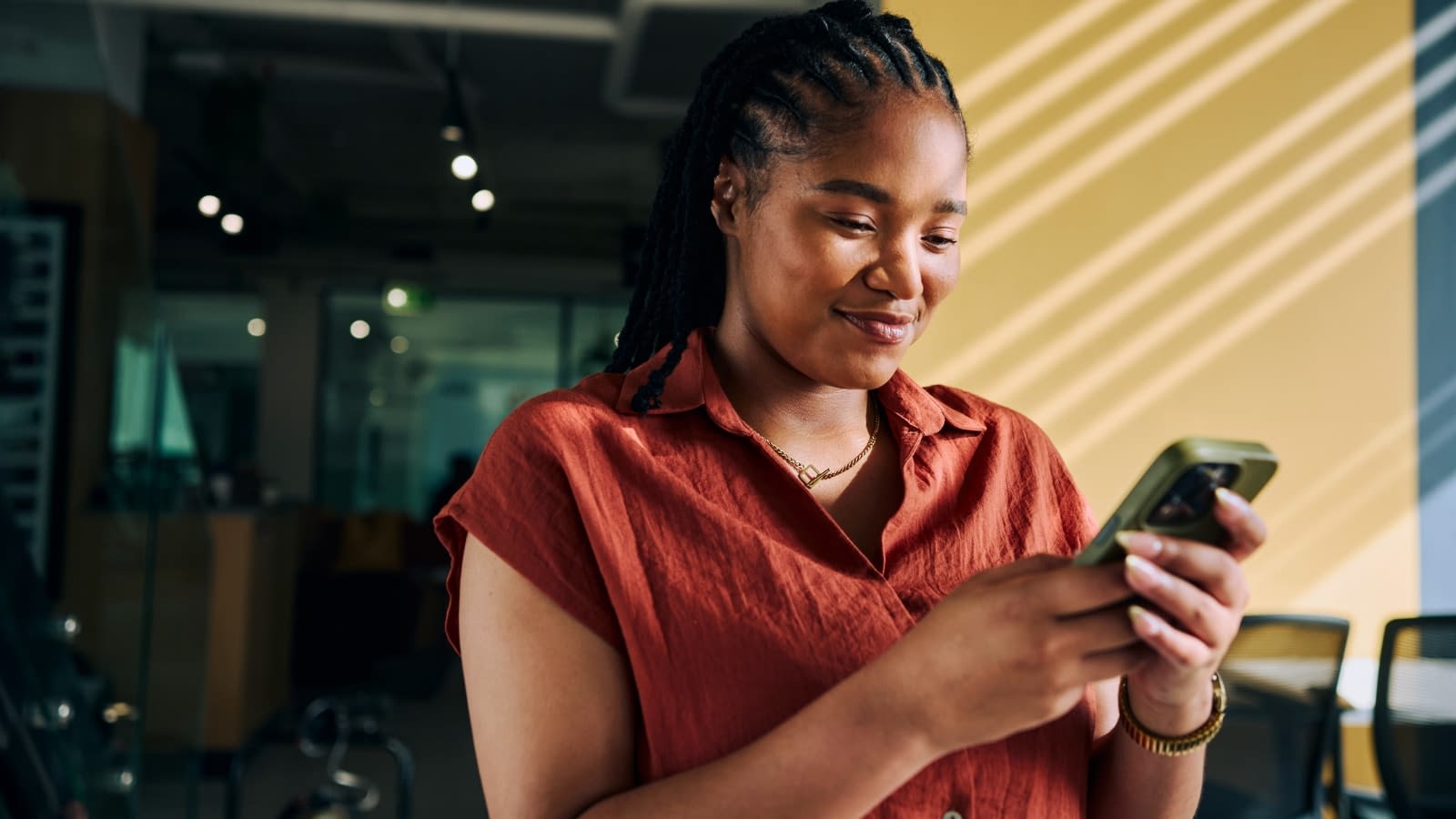 June 25 blog Young African-American woman reading about her HSA on her phone.