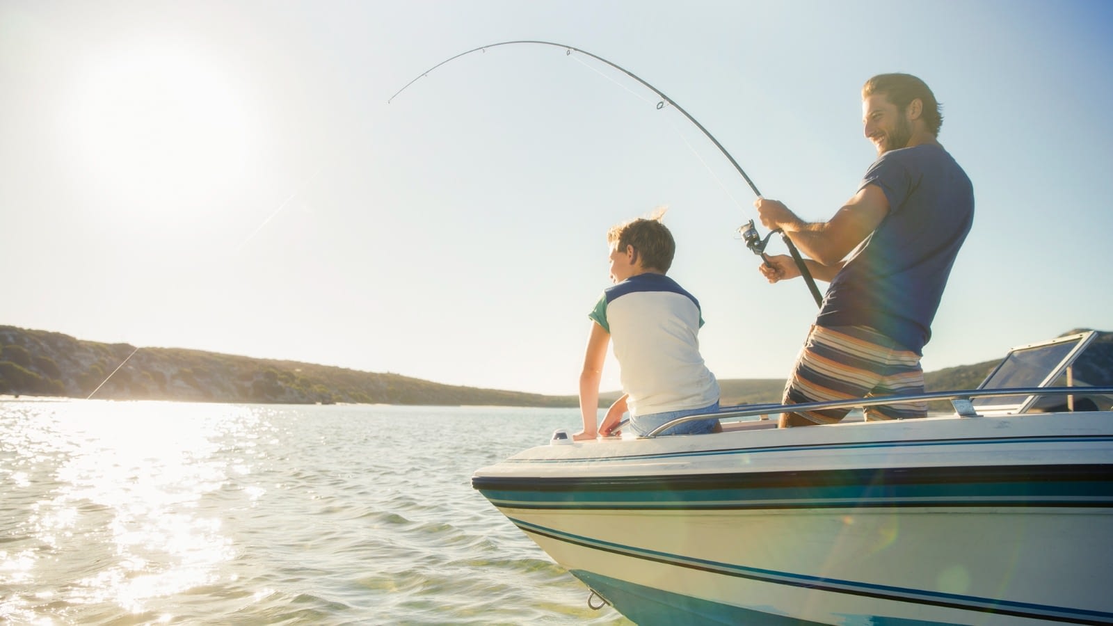 father and son fishing on a lake