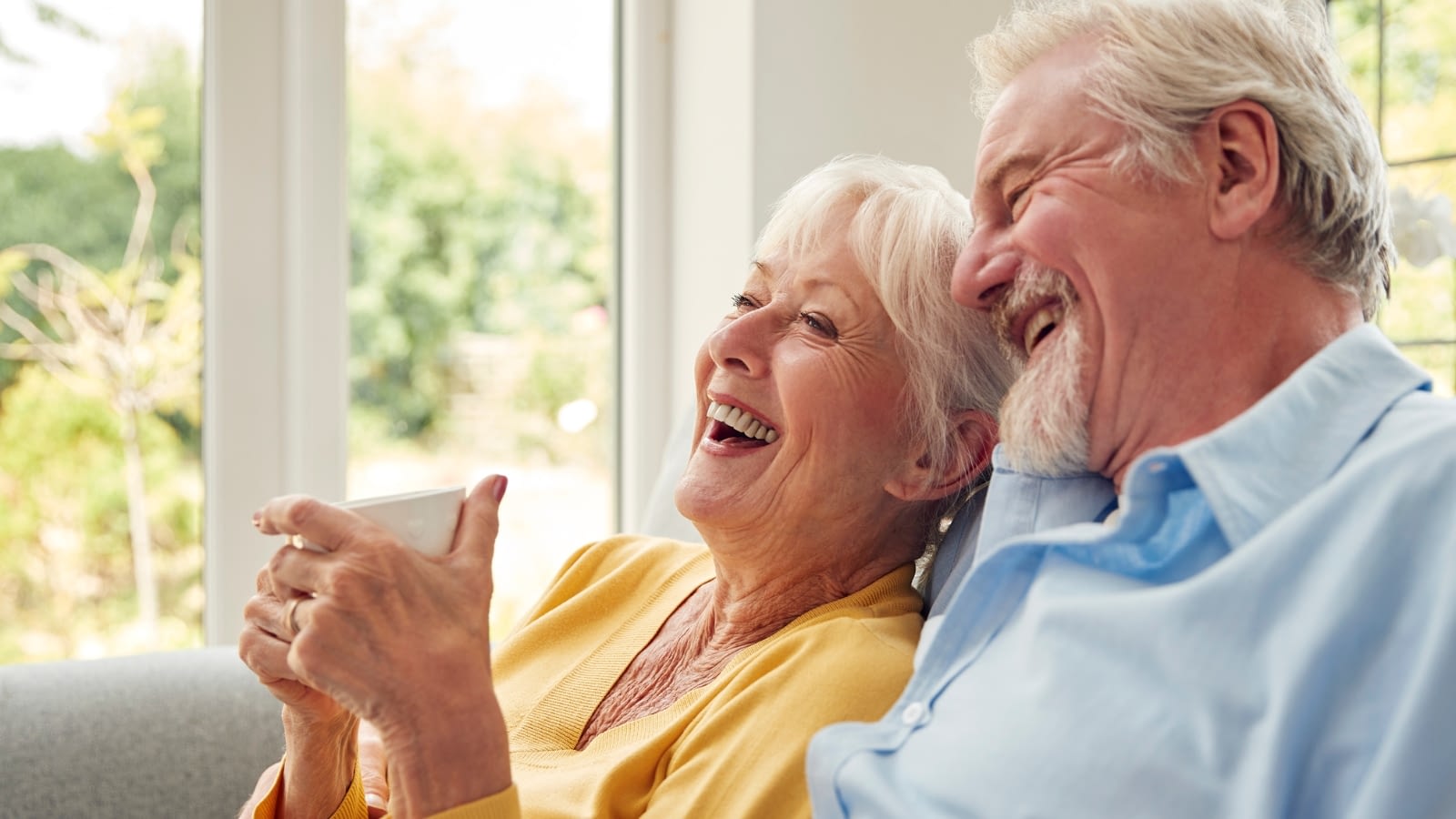 senior couple smiling on couch