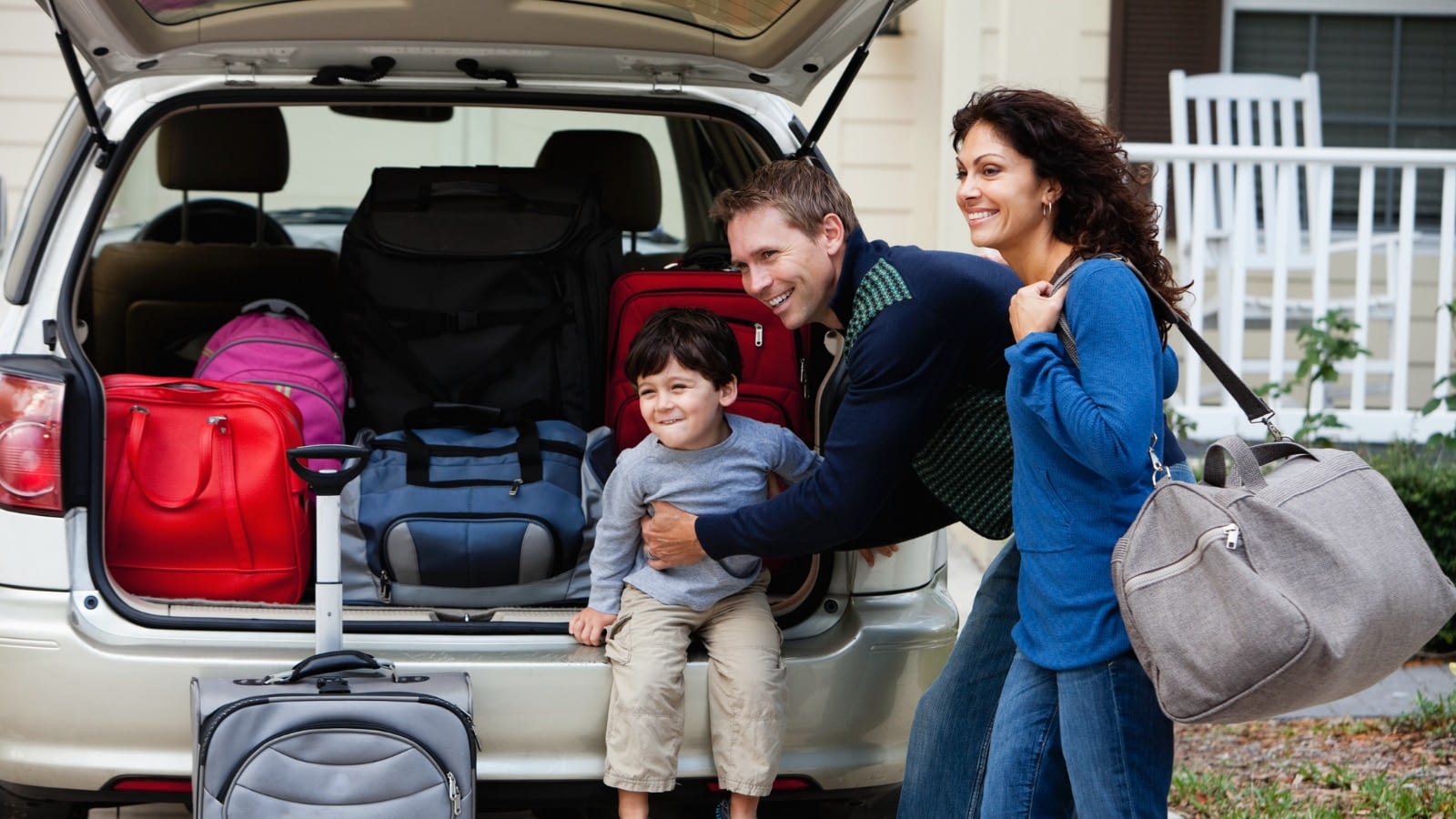 Young family packing up car for trip.