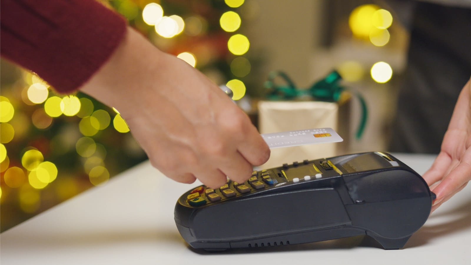Nov 4 blog close-up of person swiping credit card in shop during holidays