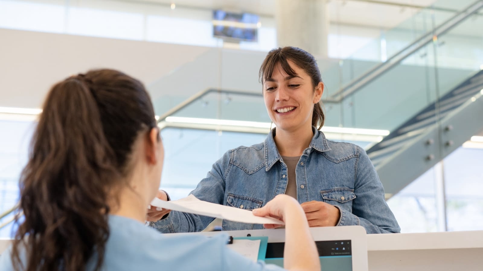 Nov 25 blog young woman filling out paperwork at dr appointment