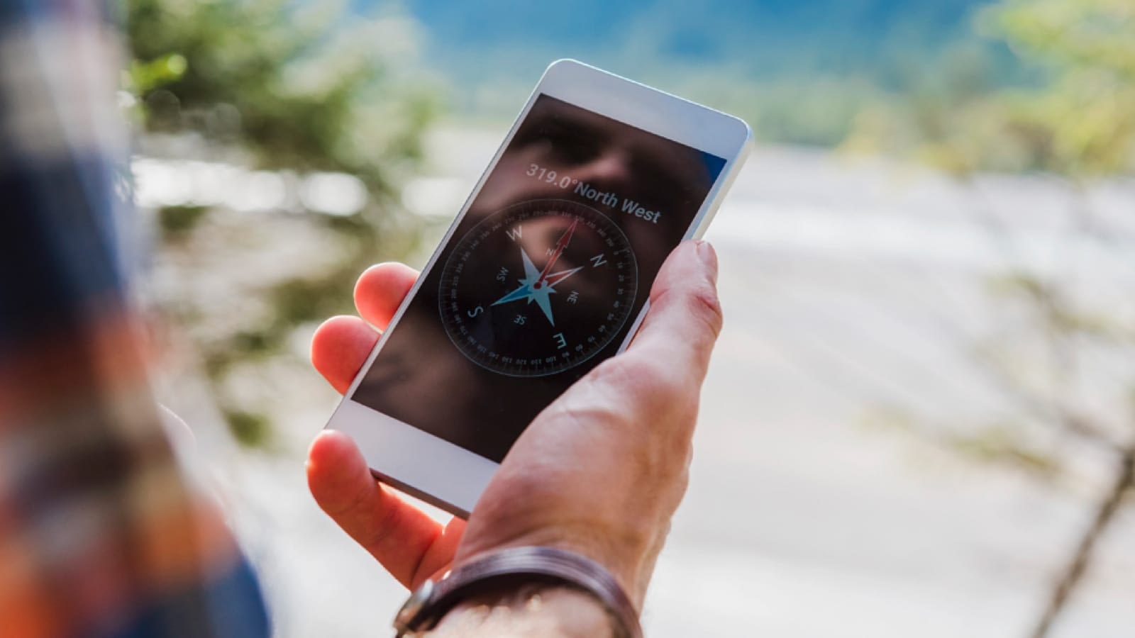 Hiker looking at a compass on their smartphone