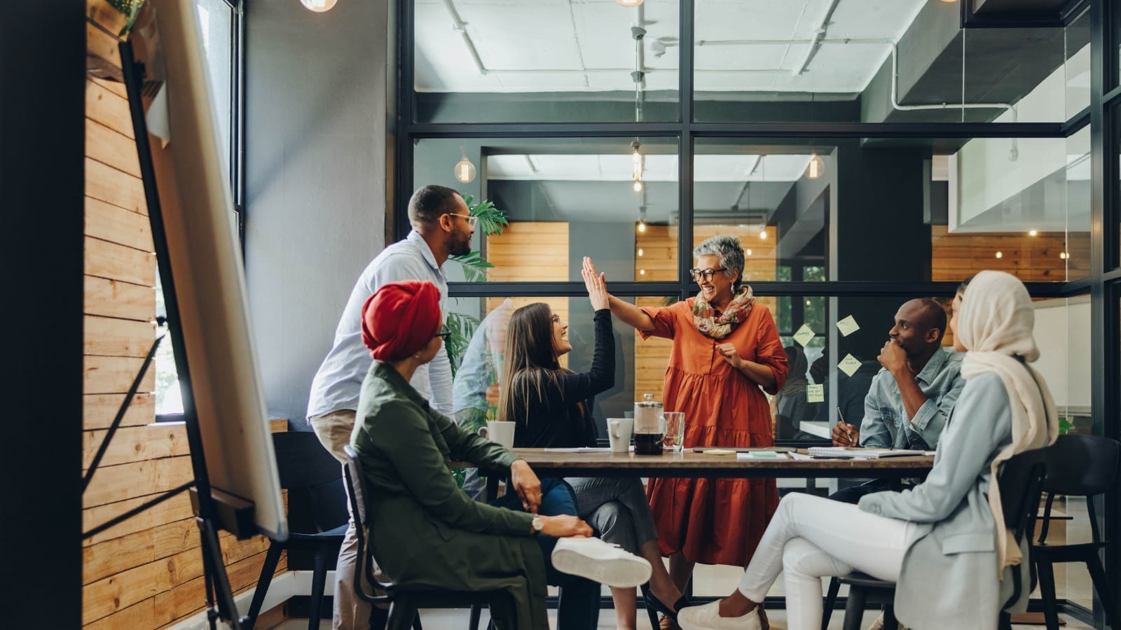 employees celebrating with boss Happy employees in a meeting