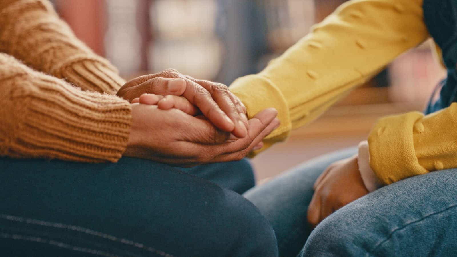 September 10th Blog close-up of two women's hands in consoling hand-hold.