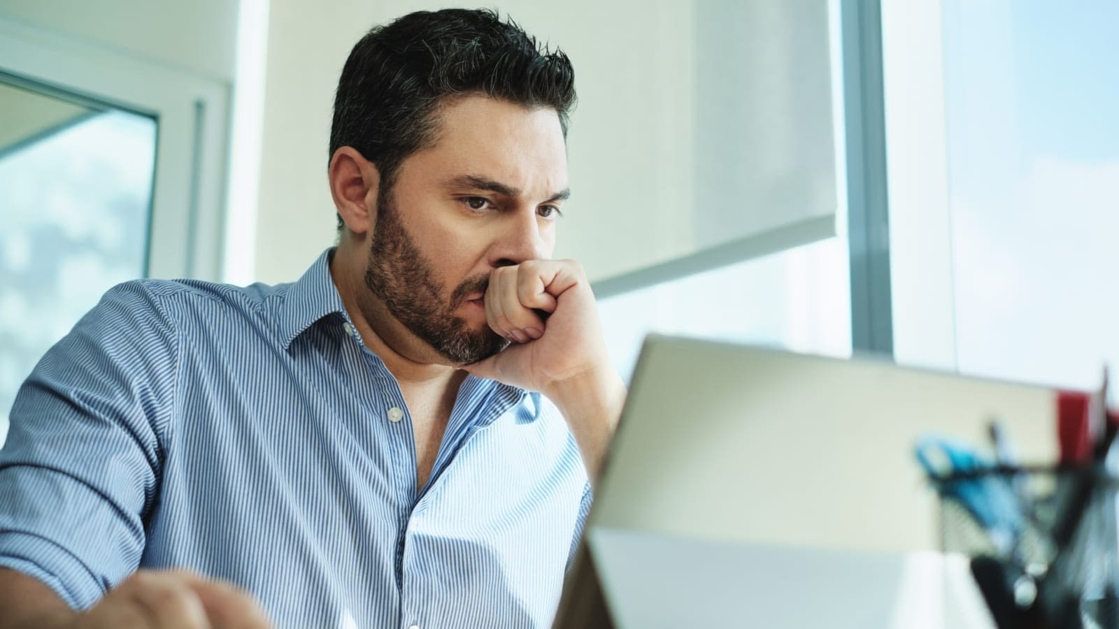 Man looking at laptop Man looking stressed at computer