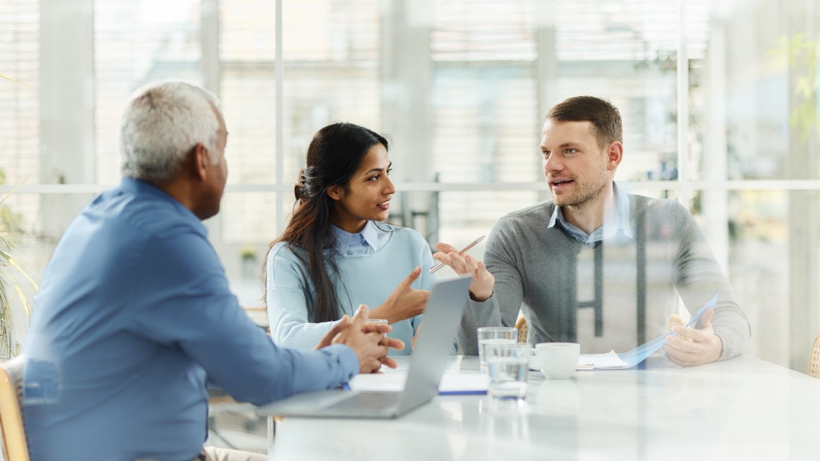 Young couple speaking with agent about life insurance.