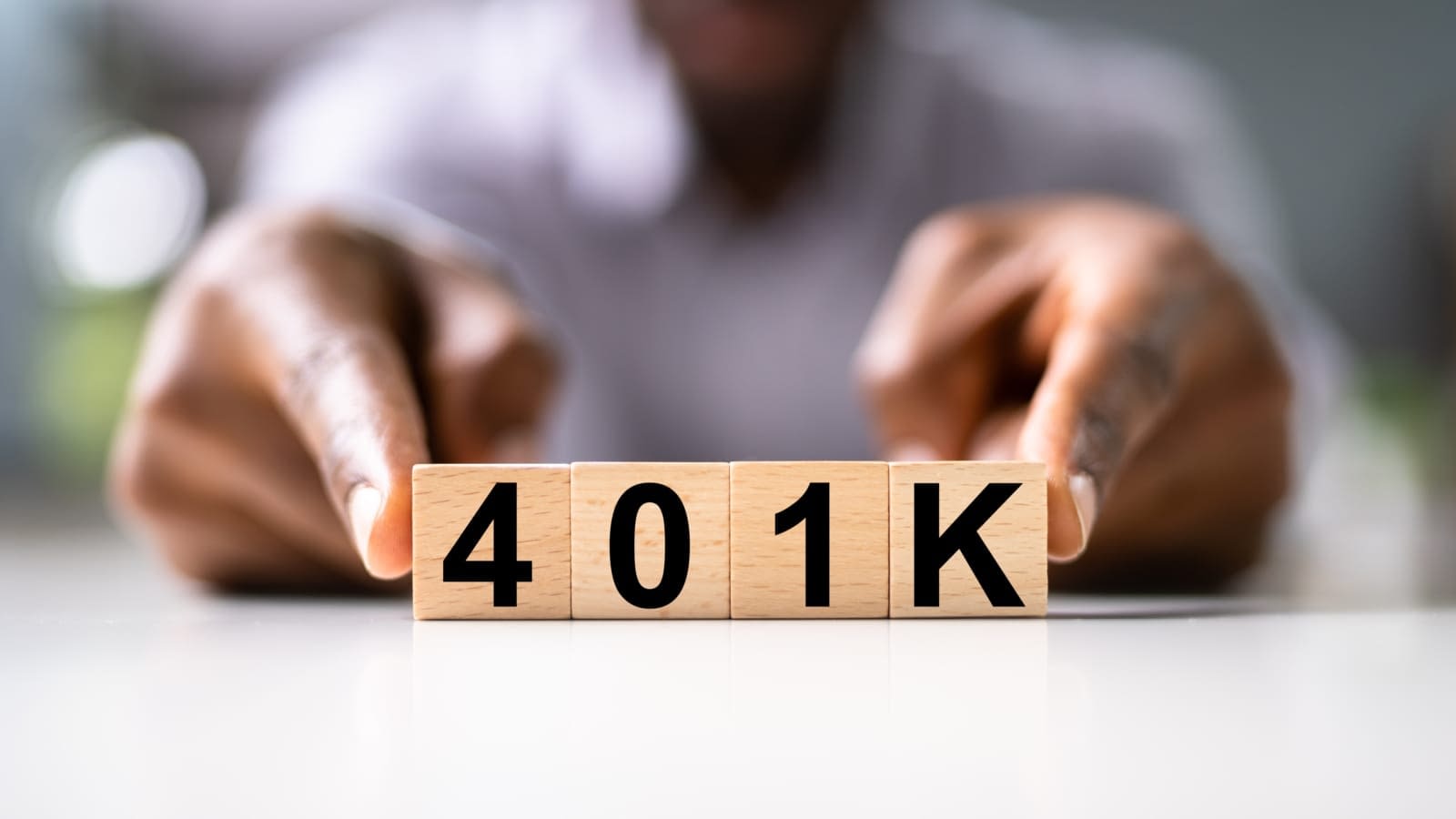 Man holding 401k Block Man with 401k Blocks in front of fingers