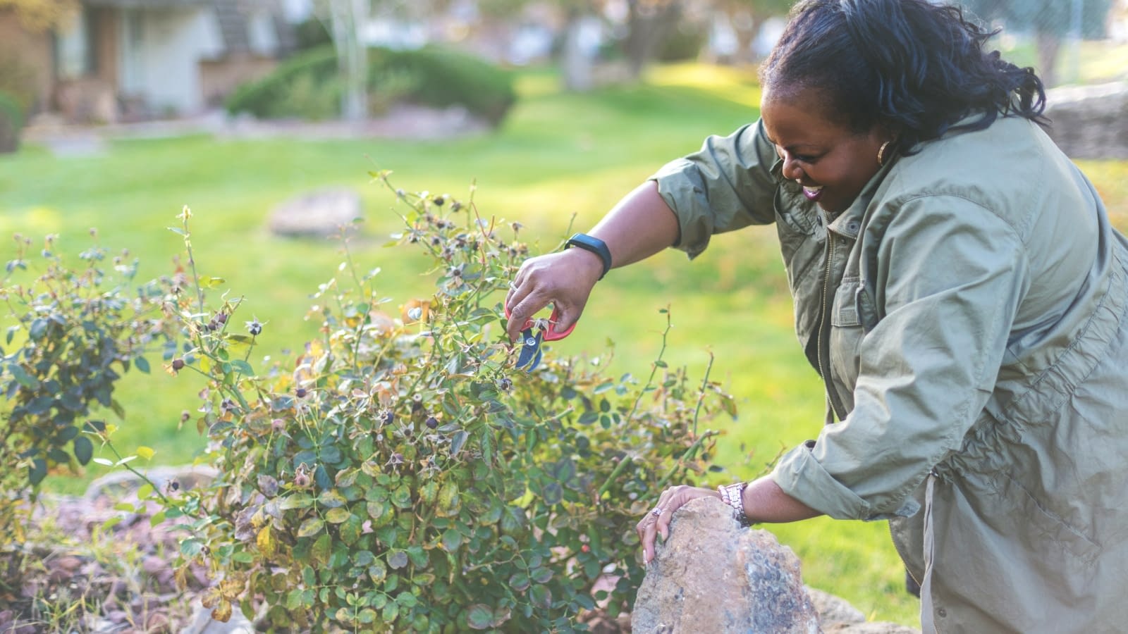April 1 blog African American female homeowner trimming shrubs